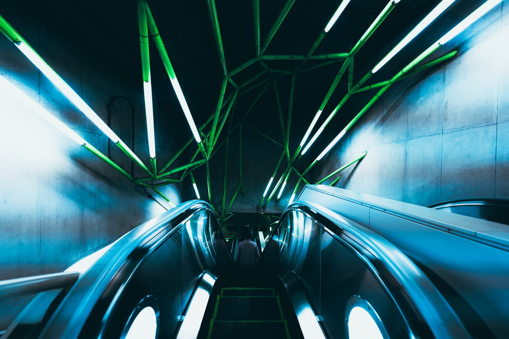 a subway station with green and blue lights