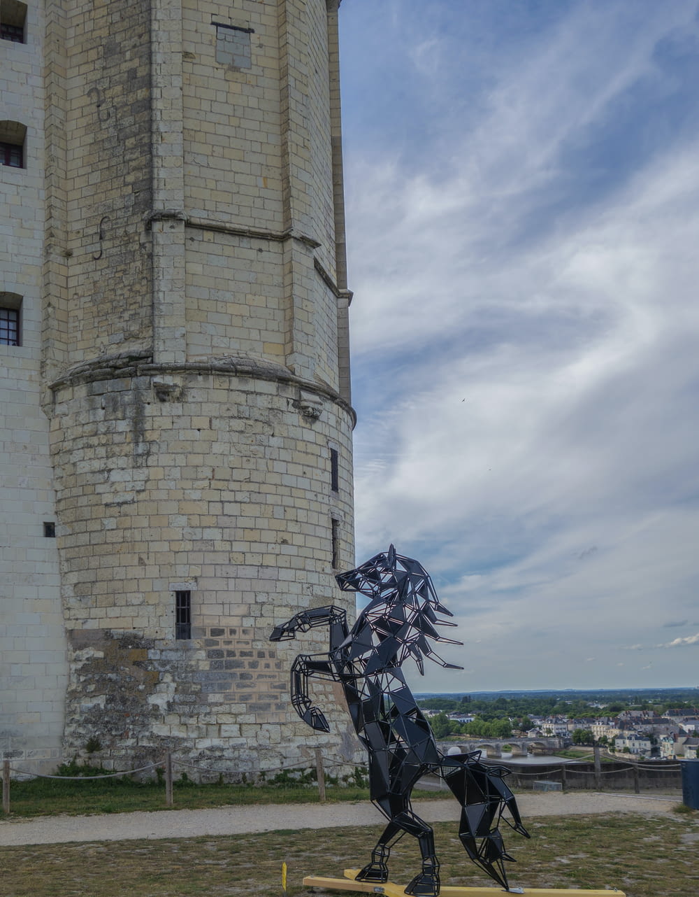 a statue of a horse is in front of a tower