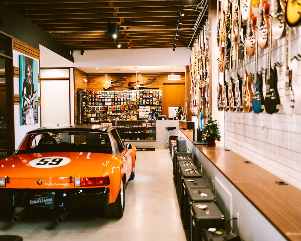 Un'auto sportiva arancione è parcheggiata in un negozio