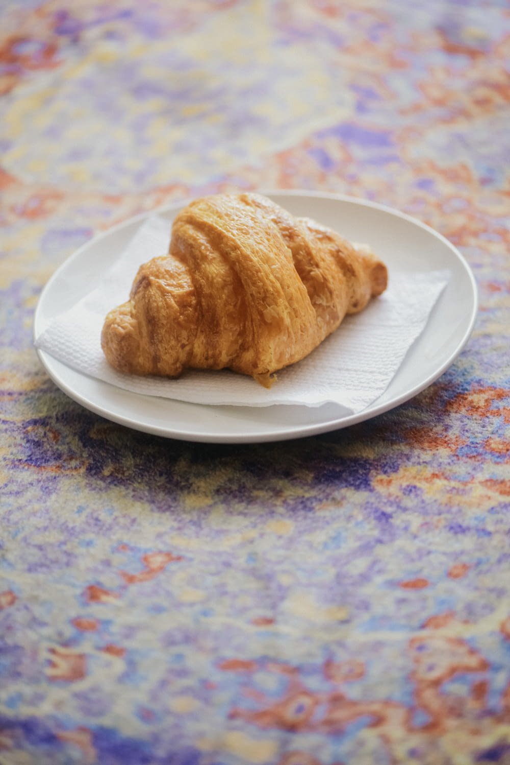 a croissant sitting on a plate on a table