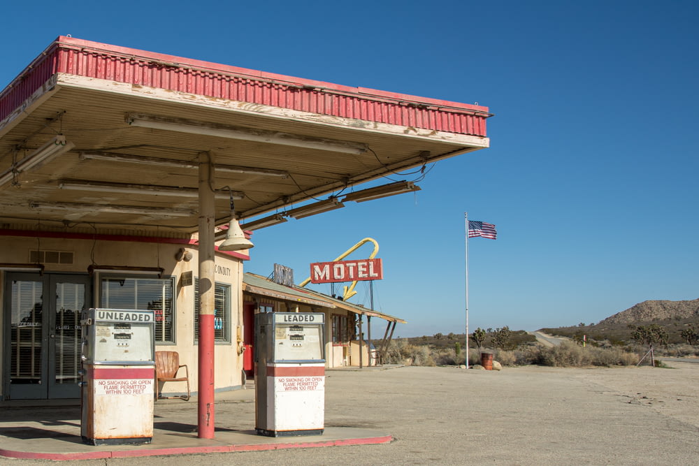 an old gas station with a flag flying in the background