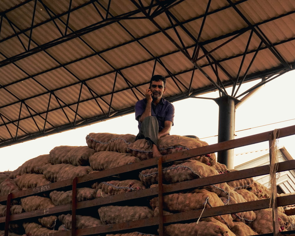 a man sitting on top of a pile of bread