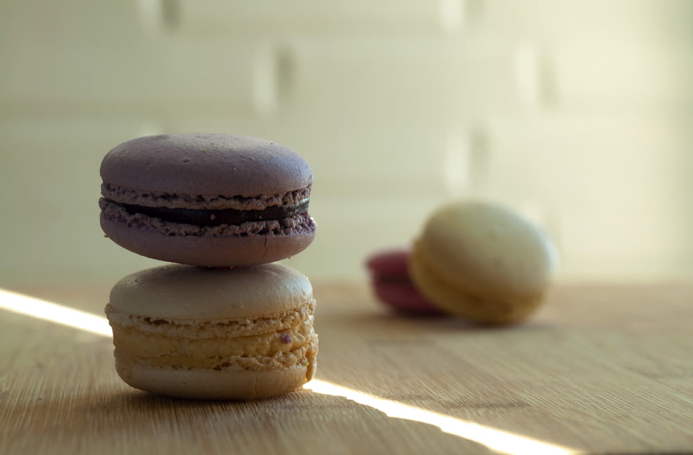 a stack of three macaroons sitting on top of a wooden table