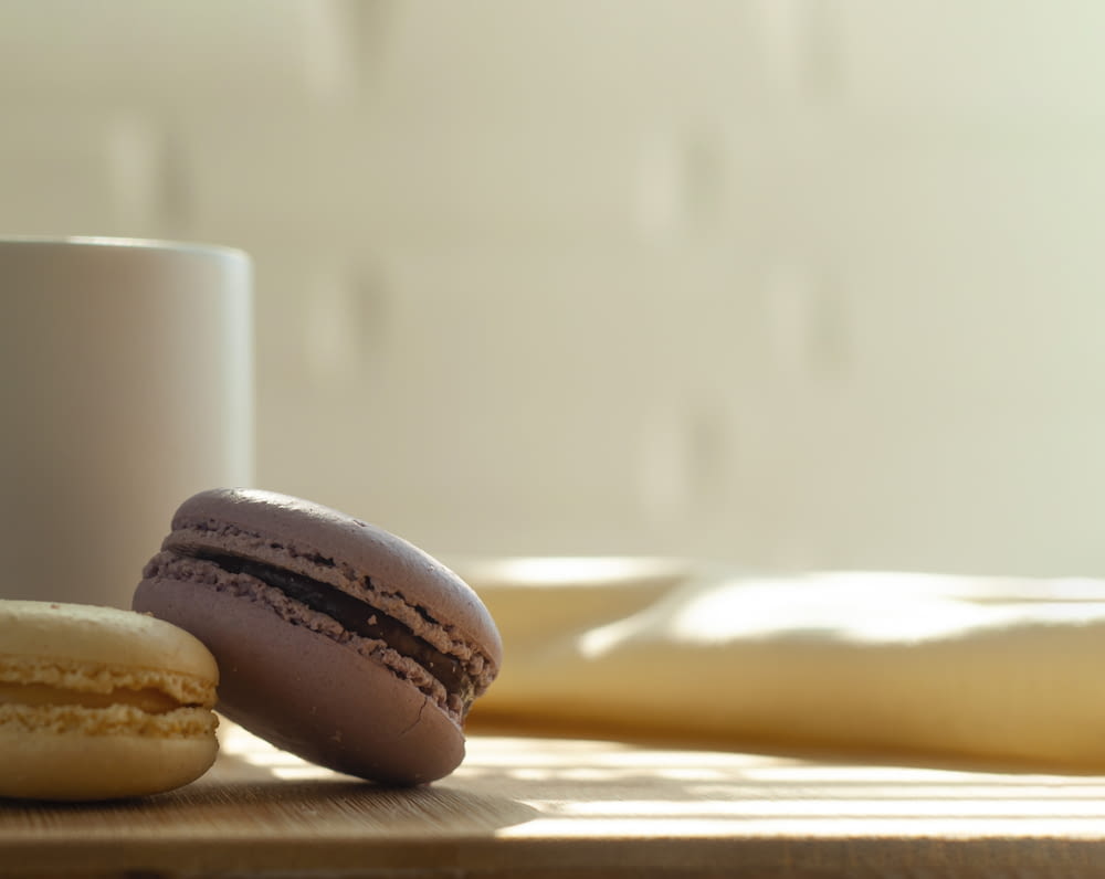 a cup of coffee and two macaroons on a table