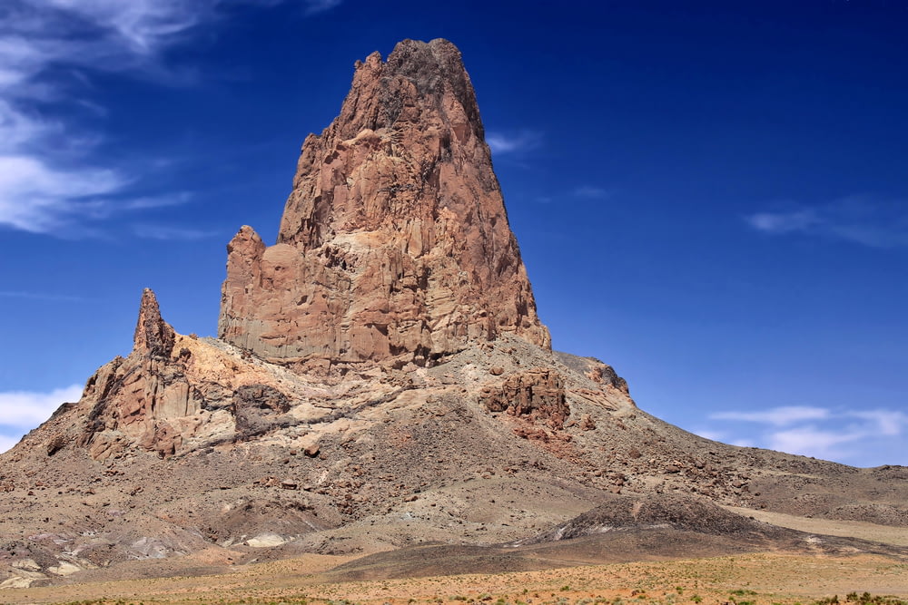 a very tall rock formation in the middle of a desert