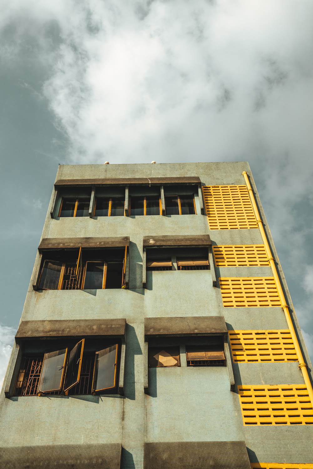 a tall building with yellow balconies and windows