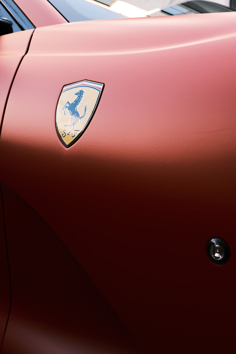 a close up of the emblem on a red sports car