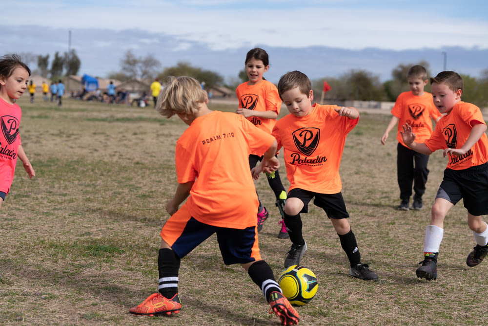 a group of young children playing a game of soccer