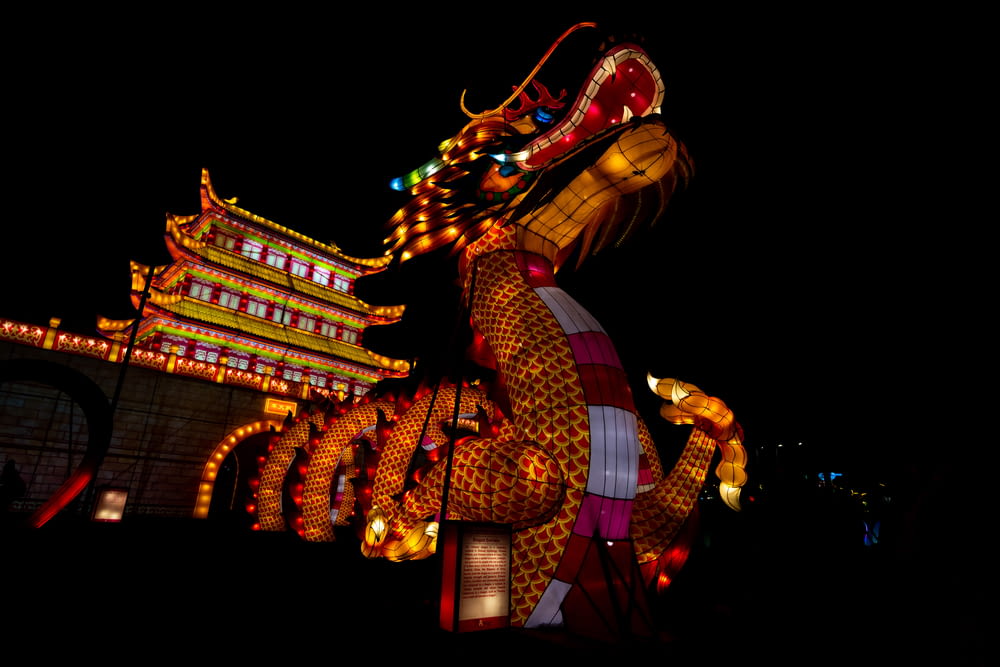 a dragon statue is lit up at night