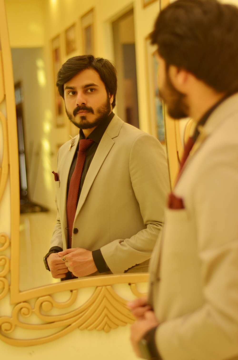 Un uomo in giacca e cravatta che si guarda allo specchio