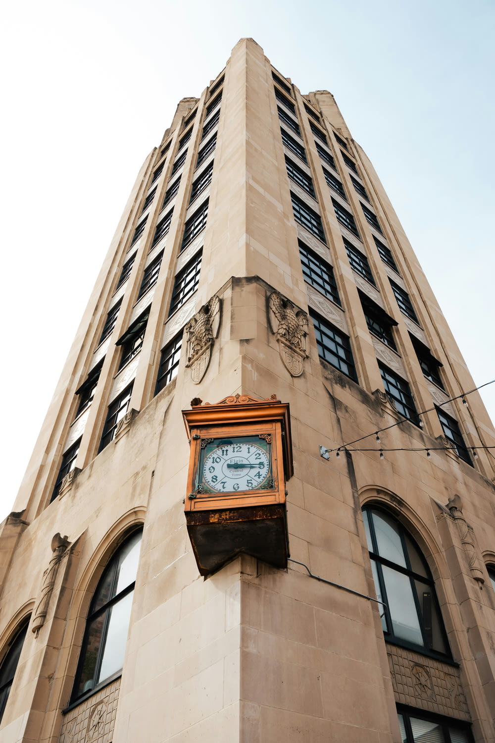 a clock mounted to the side of a tall building