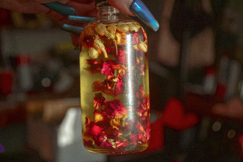a person holding a jar filled with flowers