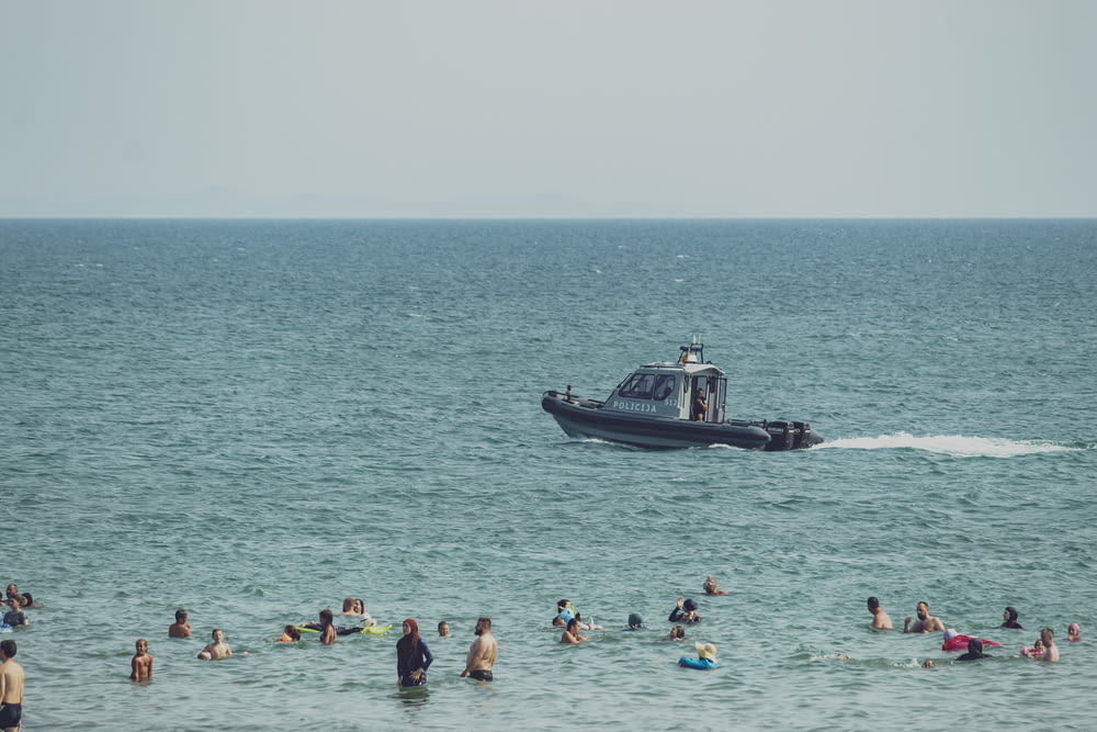a boat in the ocean with a lot of people swimming around