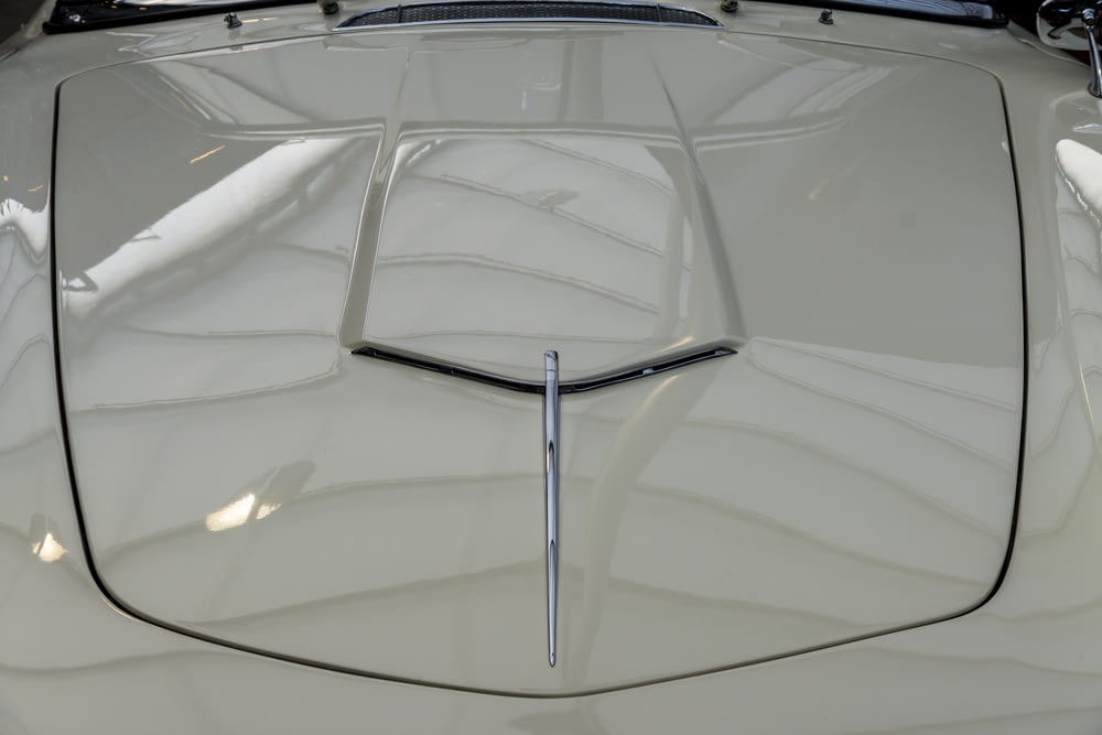 a close up of the hood of a white sports car