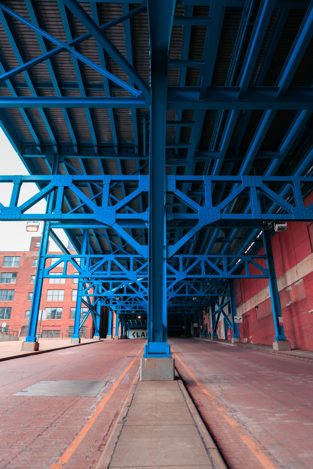 a blue metal structure with a red brick building in the background