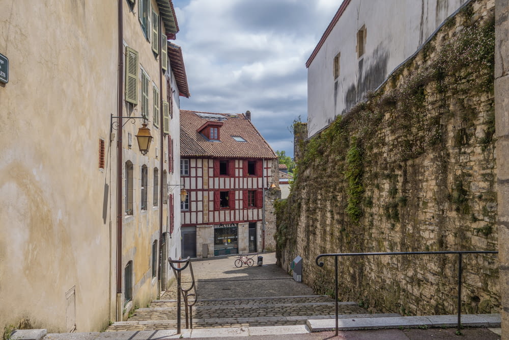 a narrow street with a stone wall and stairs