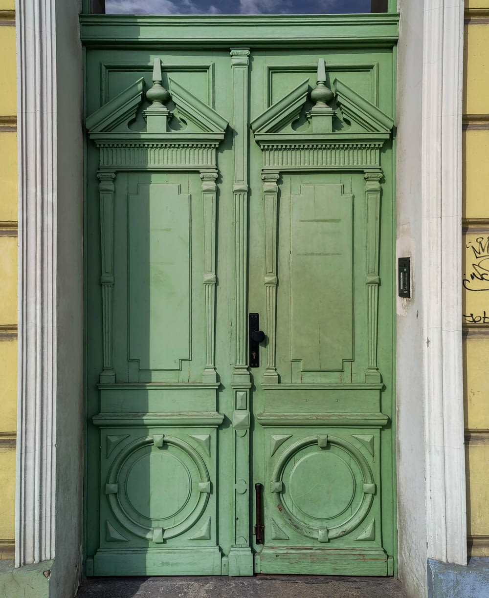 a green door with a window above it