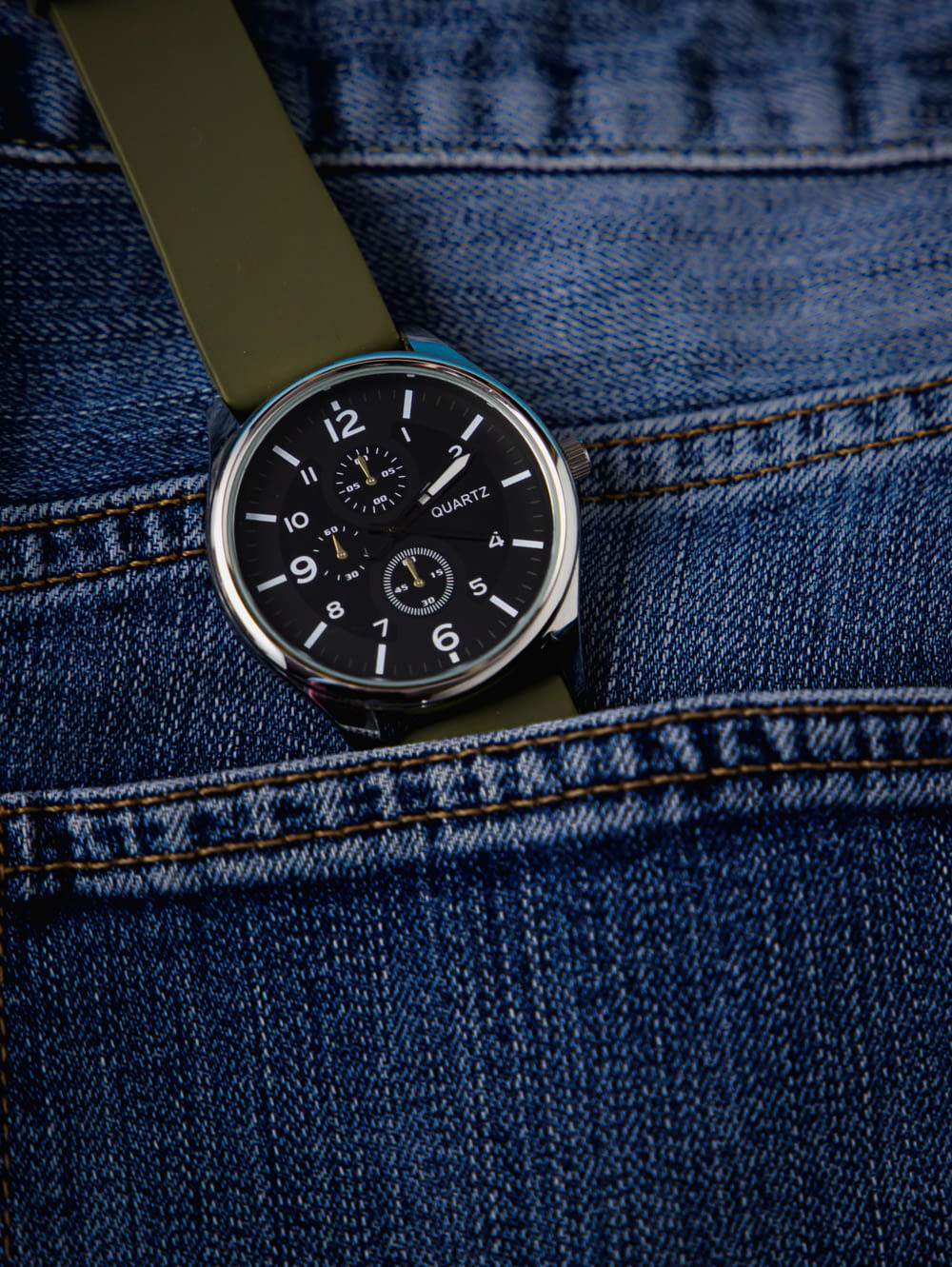 a close up of a watch in the pocket of a pair of jeans