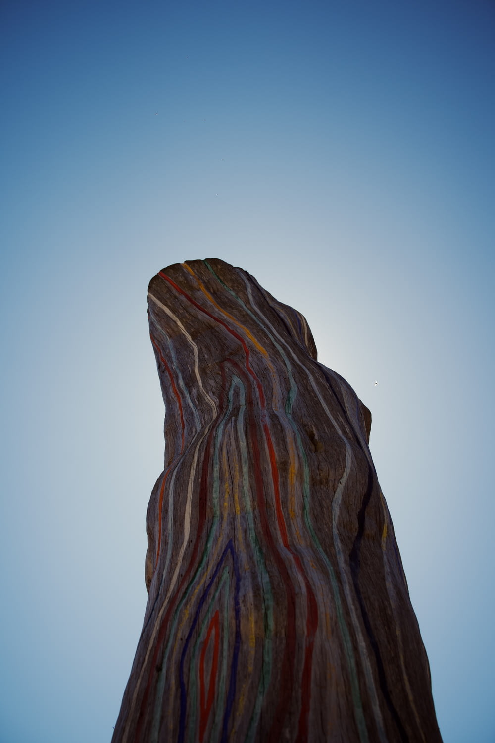 a very tall rock with a sky in the background