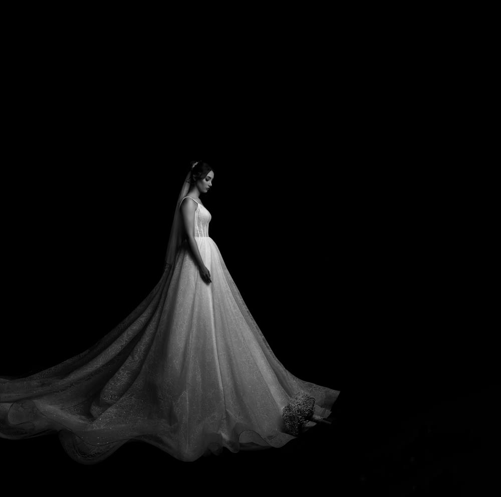a woman in a white dress is standing in the dark
