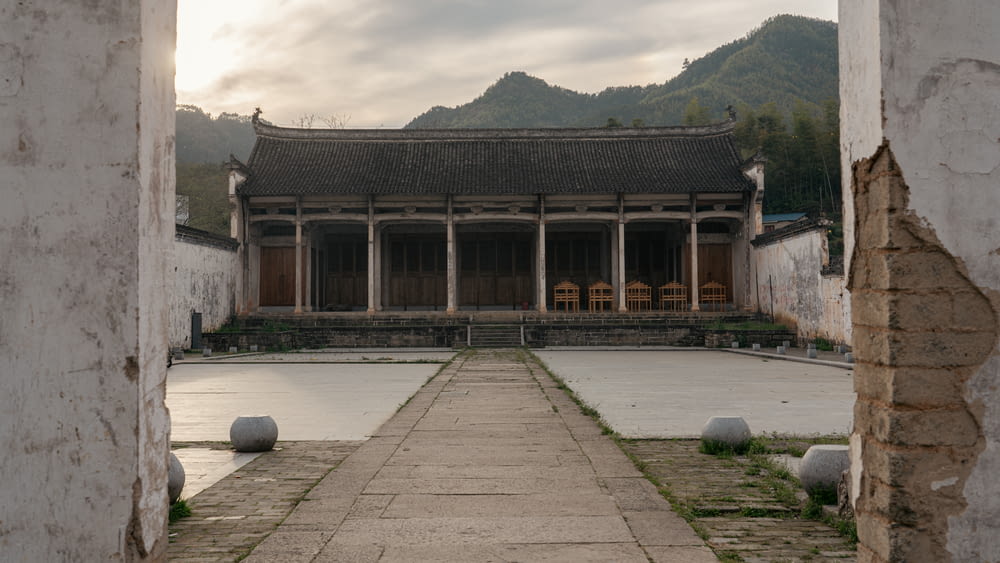 an open doorway leading to a building with mountains in the background