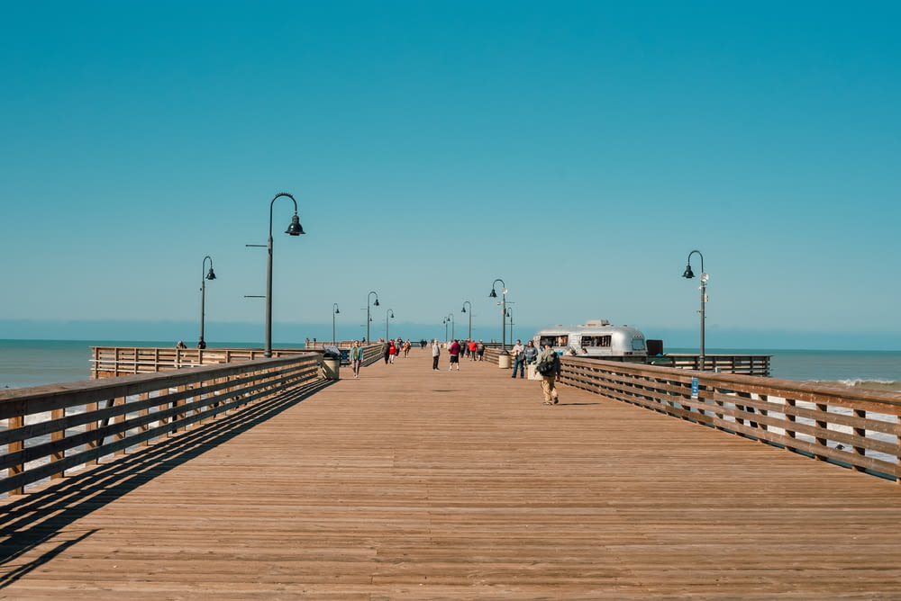 a wooden pier with people walking on it