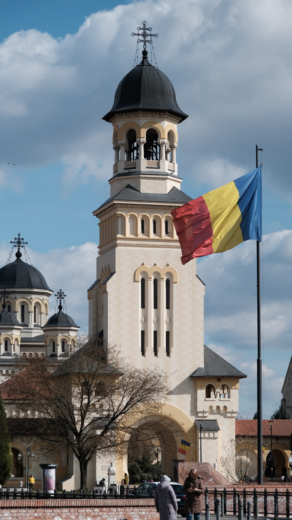 una bandiera che sventola di fronte a un edificio con una torre dell'orologio
