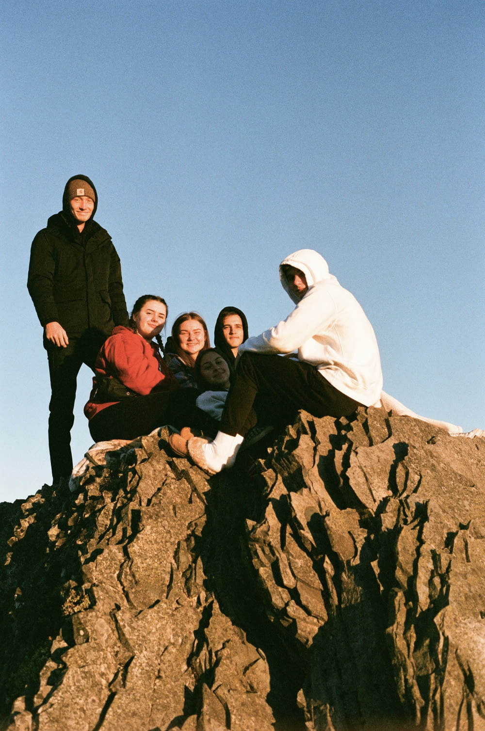 a group of people sitting on top of a rock