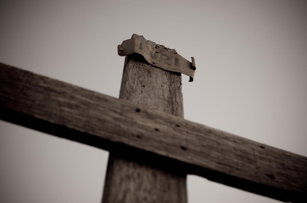a close up of a wooden cross with a sky background