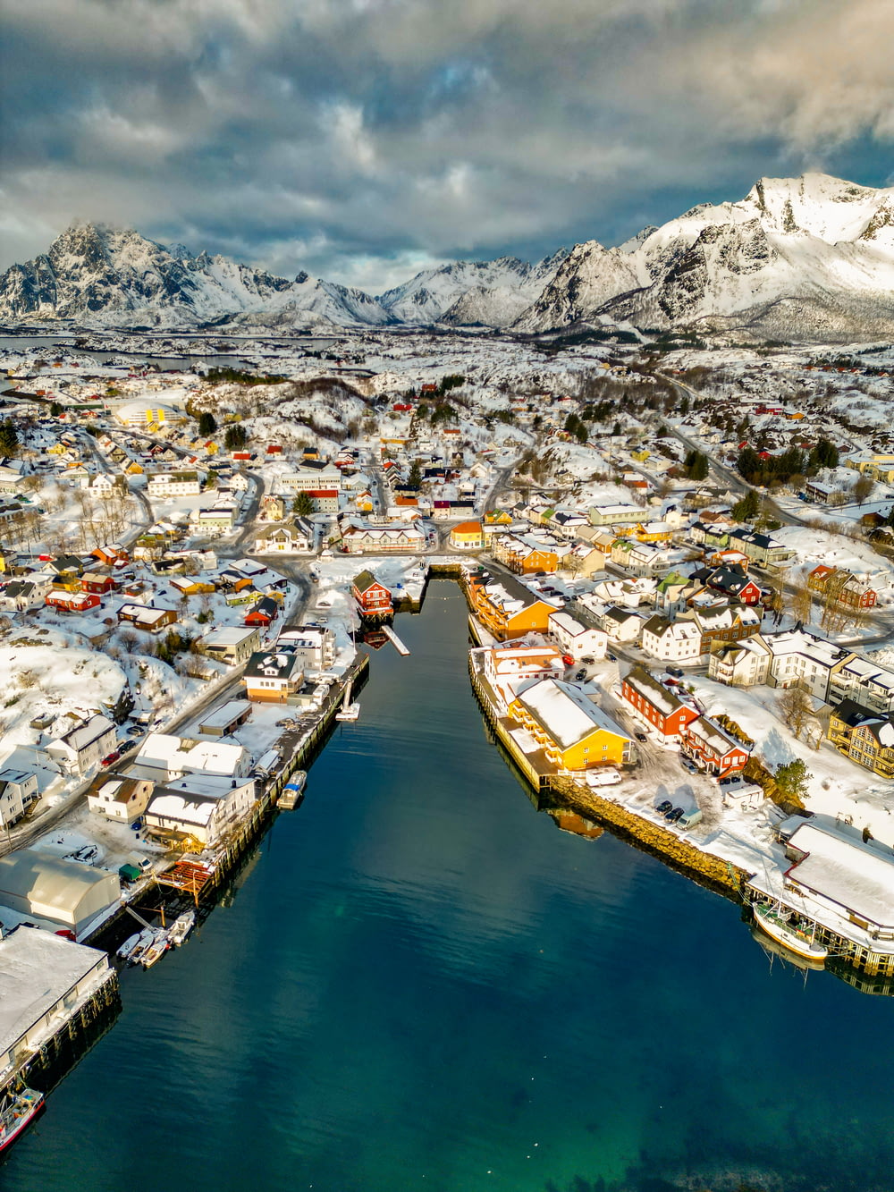 an aerial view of a snowy town and a body of water