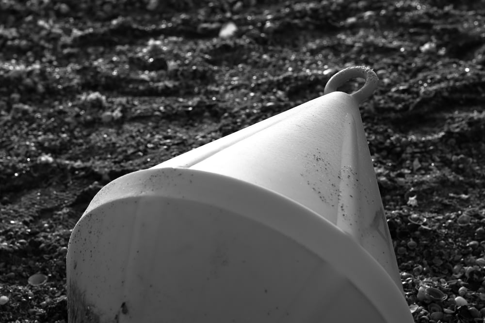 Un inodoro blanco sentado encima de un campo de tierra