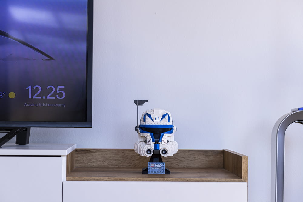 a robot toy sitting on top of a wooden shelf