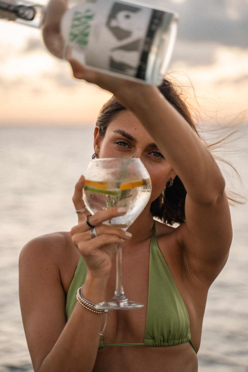 a woman in a bikini holding a wine glass