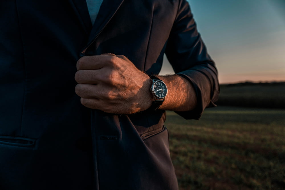 a man in a suit with a watch on his wrist