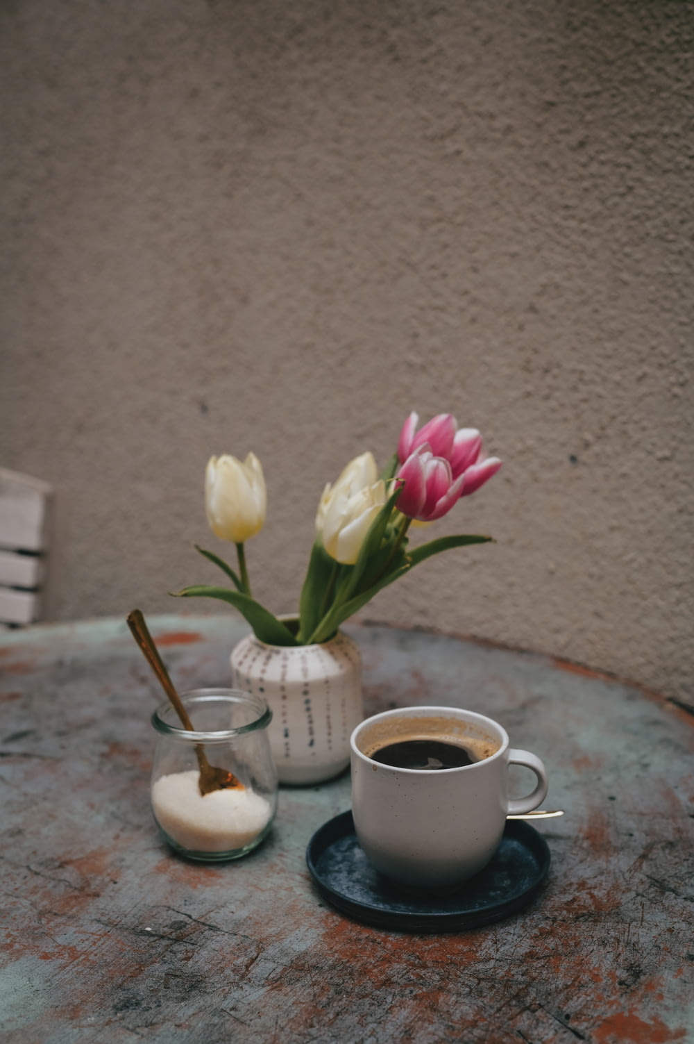 a cup of coffee and some flowers on a table