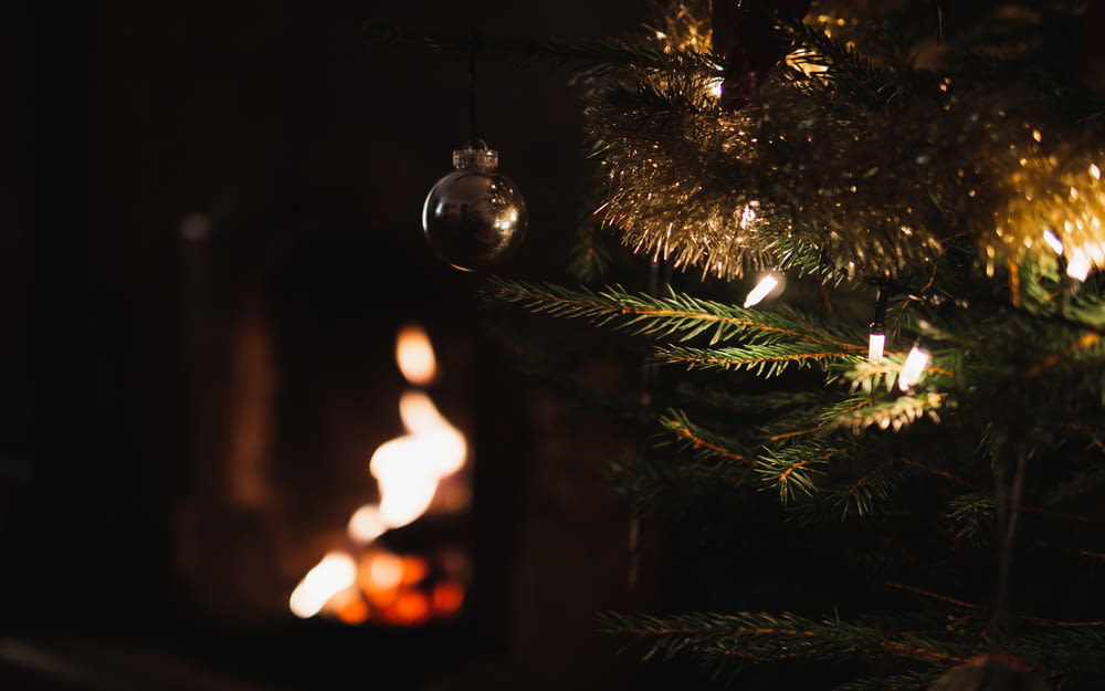 a christmas tree with a lit fireplace in the background
