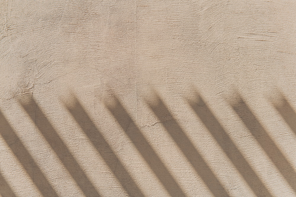 sombras projetadas em uma parede e um banco