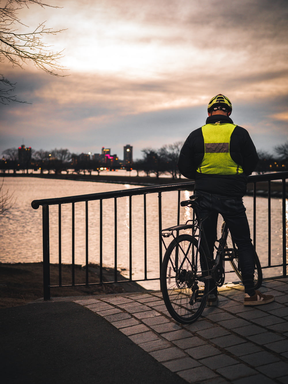 a man standing next to a bike next to a body of water
