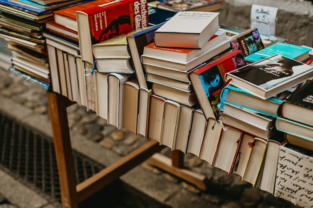 a pile of books sitting on top of a wooden table