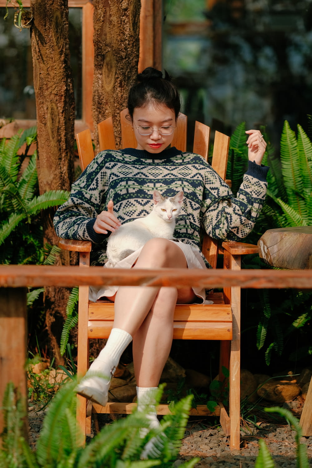 a woman sitting in a chair holding a cat