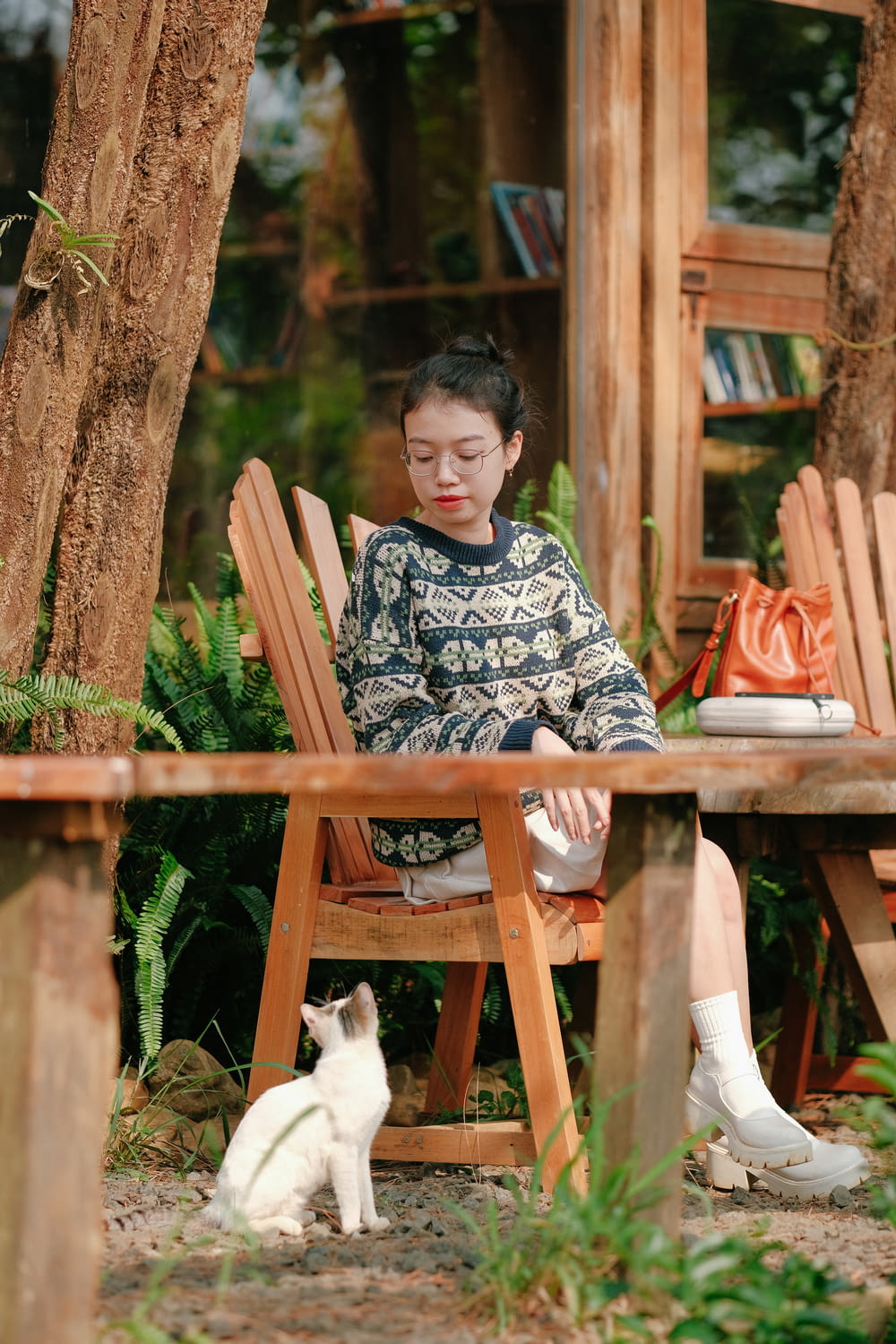 a woman sitting in a chair next to a cat