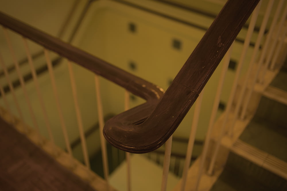 a close up of a wooden hand rail on a staircase