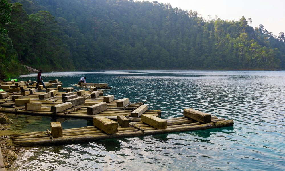 Un grupo de personas de pie en balsas de madera en el agua