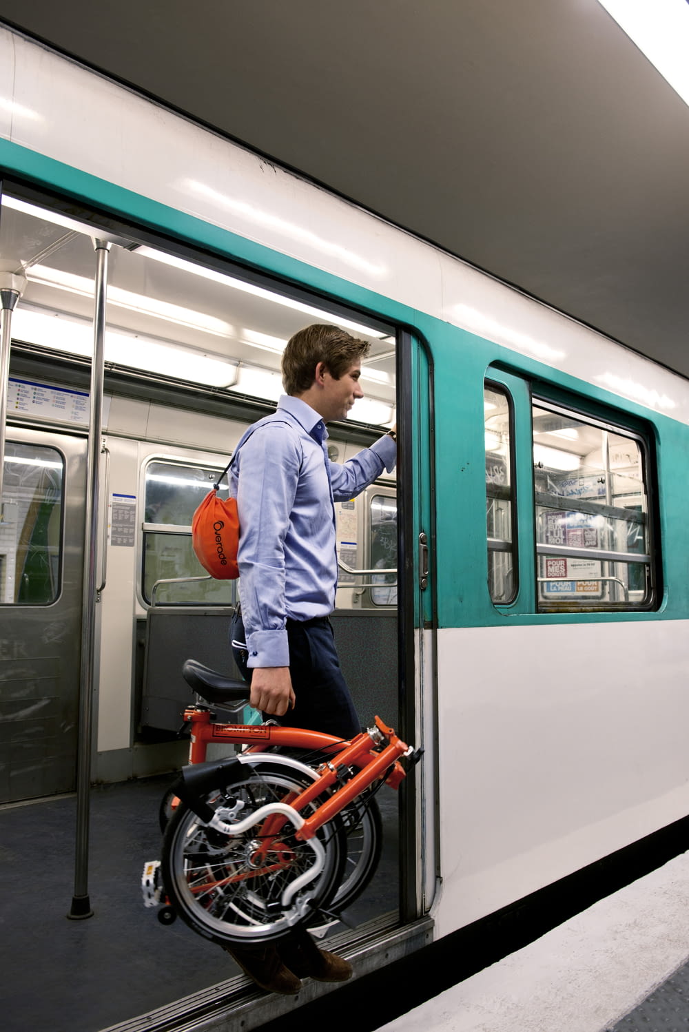 a man standing next to a green and white train