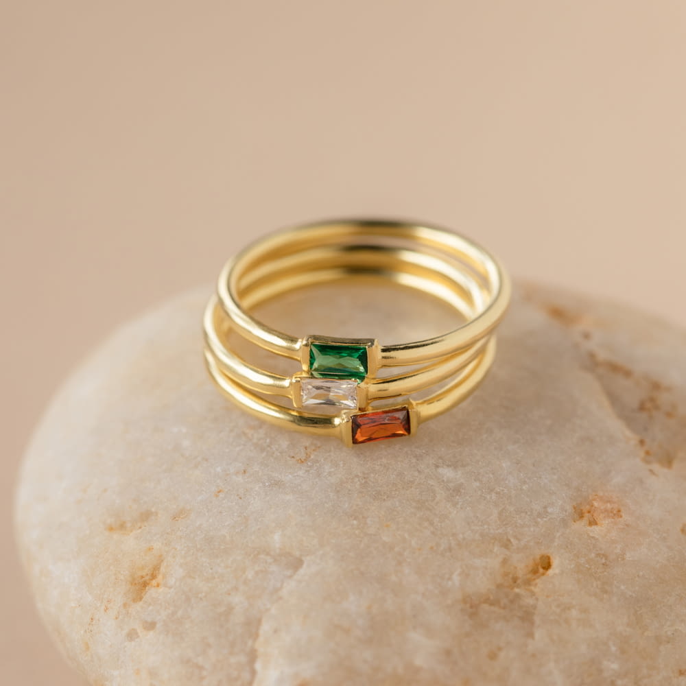 a stack of three rings sitting on top of a rock