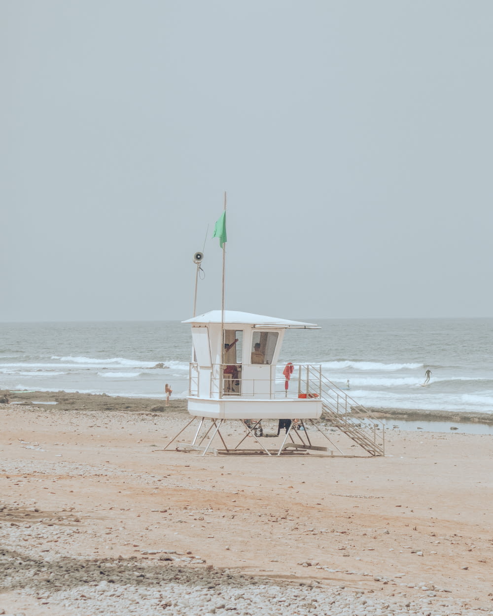 a lifeguard stand on the beach with a flag on it