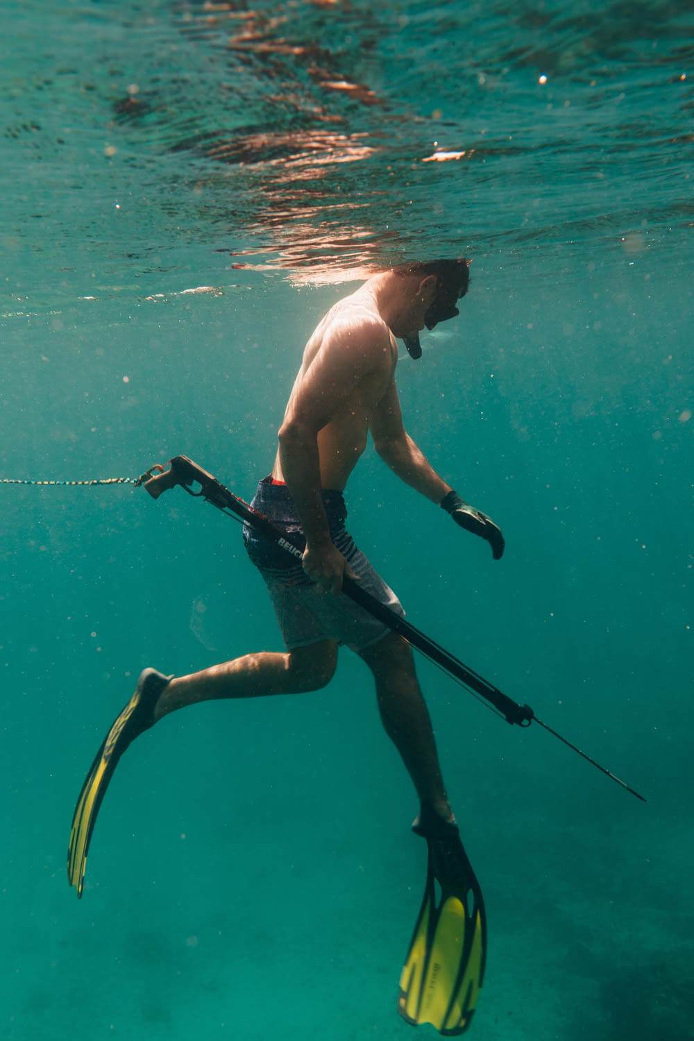 a man is swimming in the water with a pair of skis