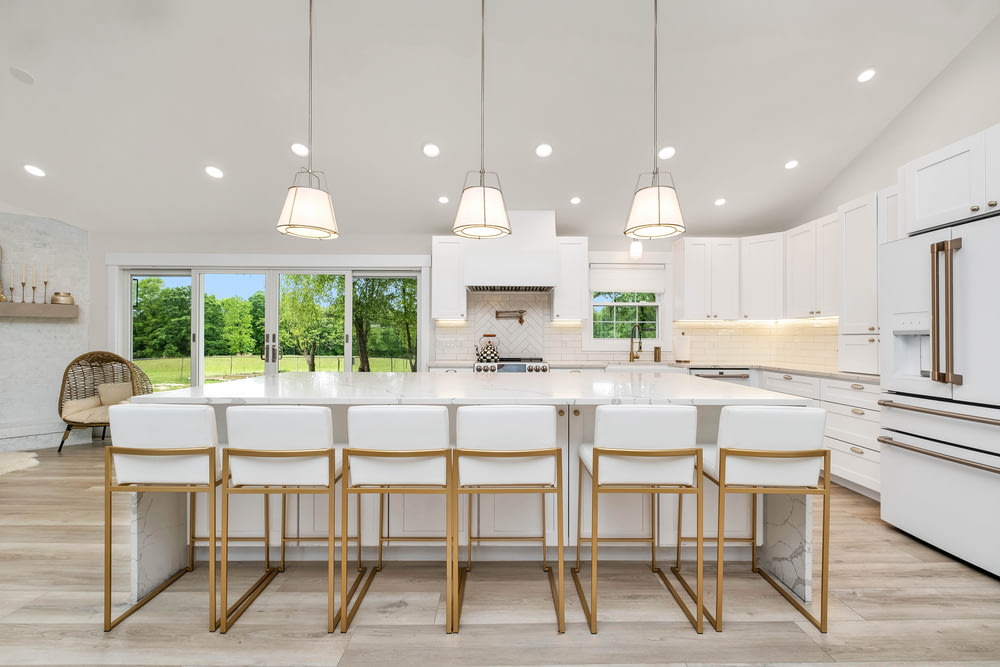 a large kitchen with a center island and white cabinets