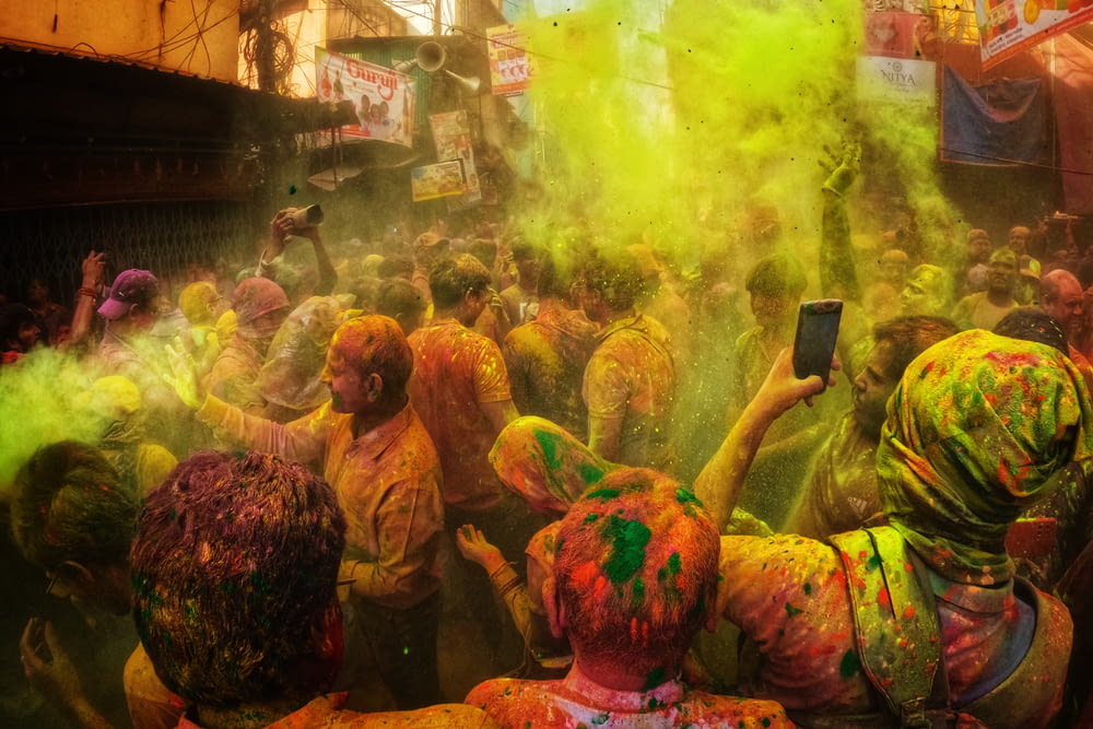 a crowd of people covered in colored powder