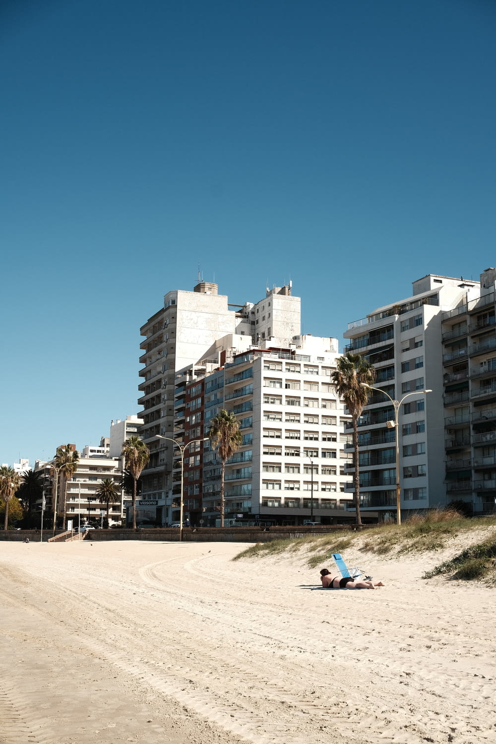 a beach scene with a building in the background